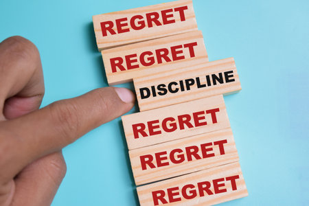 Discipline or regret on stacked wooden cubes on the table. Business and finance conceptの写真素材