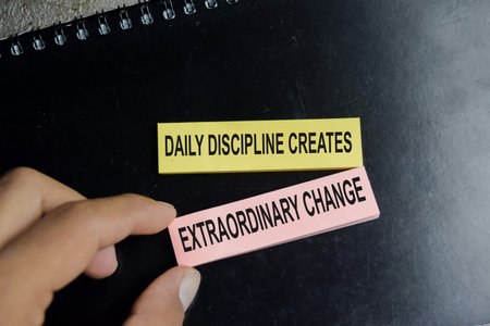 Concept of success daily discipline creates extraordinary change write on sticky notes isolated on Wooden Table.の写真素材