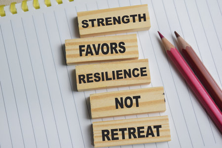 Strength favors resilience not retreat on stacked wooden cubes on the table.