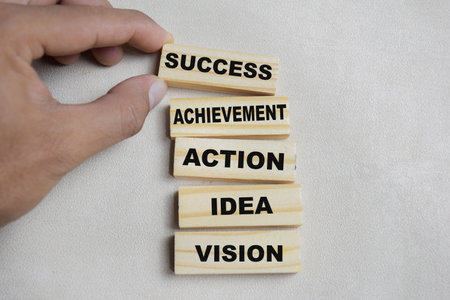 Achievement, action, idea, vision on stacked wooden cubes on the table. Business and finance conceptの写真素材
