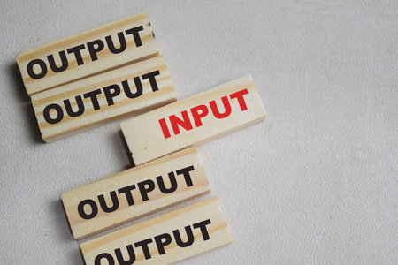 Two words input or output. Choose input on stacked wooden cubes on the table.の写真素材