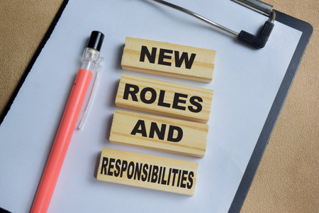 New roles and responsibilities on stacked wooden cubes on the table.の写真素材