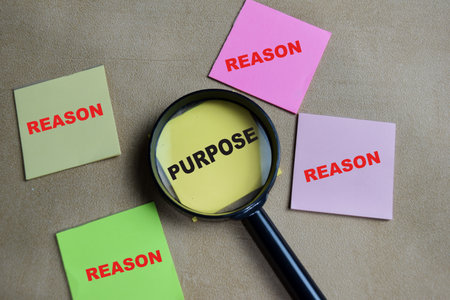 Concept of purpose and reason write on sticky notes isolated on Wooden Table.の写真素材