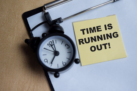 Concept of time is running out write on sticky notes isolated on Wooden Table.の写真素材