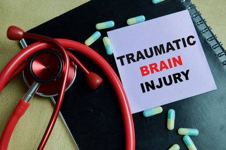 Concept of traumatic brain injury write on sticky notes isolated on Wooden Table.の写真素材