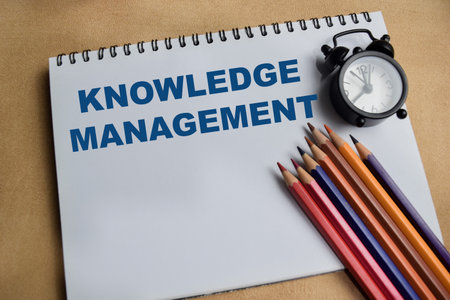 Concept of knowledge management write on book with keywords isolated on Wooden Table.