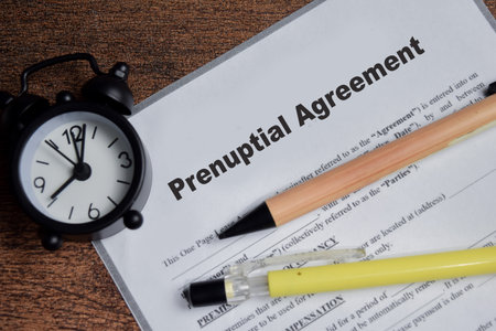 Concept of prenuptial agreement contract write on clipboard isolated on Wooden Table.の写真素材