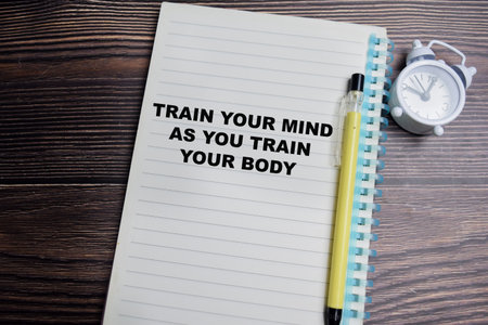 Concept of train your mind as your train your body write on book isolated on Wooden Table.
