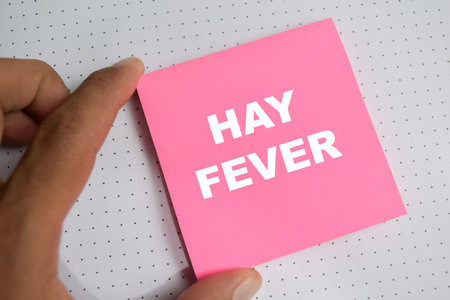 Concept of hay fever - allergy and seasonal illness write on sticky notes isolated on Wooden Table.