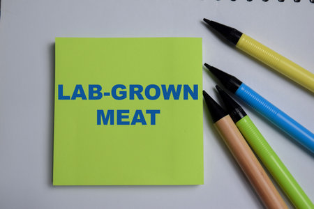Concept of lab-grown meat write on sticky notes isolated on Wooden Table.