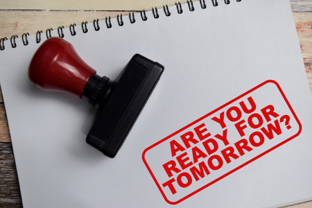 Red Handle Rubber Stamper and are you ready for tomorrow text above book isolated on wooden backgroundの写真素材