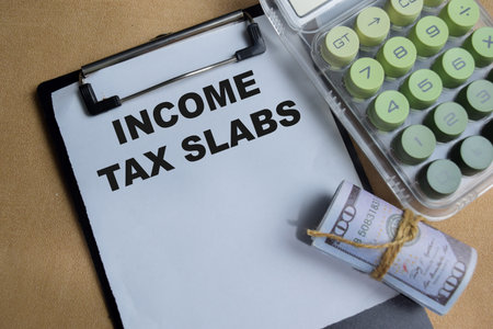 Concept of income tax slabs write on clipboard isolated on Wooden Table.の写真素材