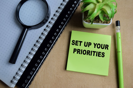 Concept of set up your priorities write on sticky notes isolated on Wooden Table.の写真素材