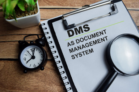 Concept of DMS as Document Management System write on clipboard isolated on Wooden Table.の写真素材