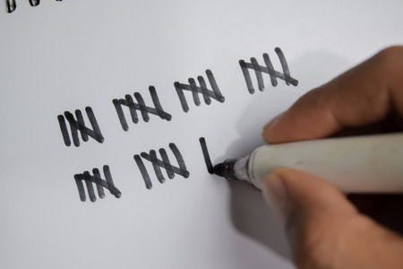 Concept of hand counting write on book isolated on Wooden Table.の写真素材