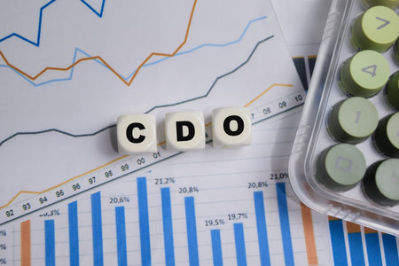 CDO stacked wooden cubes with financial graphs on the table.の写真素材