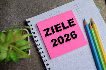 Concept of 2026 goals in German write on sticky notes isolated on Wooden Table.