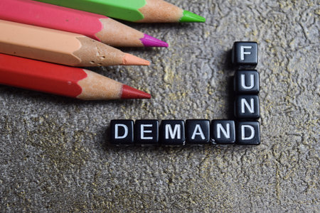 Concept of demand and fund words arranged with on wooden letter blocks.