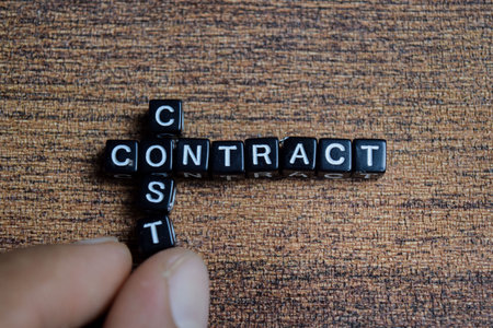 Concept of cost and contract words arranged with on wooden letter blocks.の写真素材