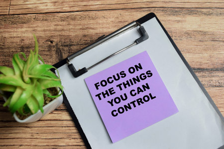 Concept of focus on the things you can control write on sticky notes isolated on Wooden Table.の写真素材