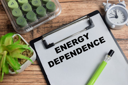 Concept of energy dependence write on clipboard isolated on Wooden Table.