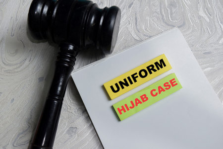 Concept of hijab case write on sticky notes isolated on Wooden Table. Representing religious...