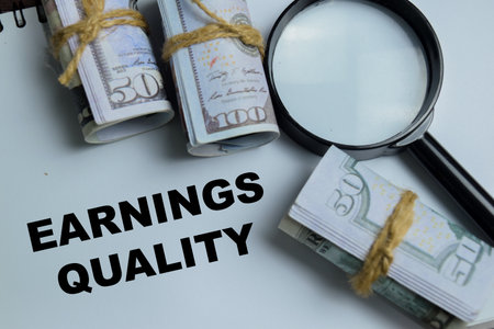 Concept of earnings quality write on book isolated on Wooden Table. Representing sustainable profit...