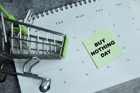 Concept of buy nothing day write on sticky notes isolated on Wooden Table.