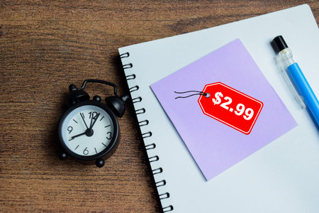 Concept of price tag with $2.99 write on sticky notes isolated on Wooden Table.