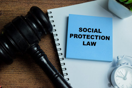 Concept of social protection law write on sticky notes isolated on Wooden Table.