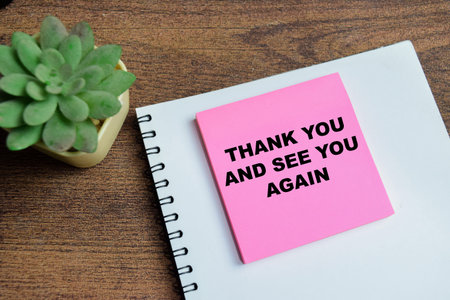 Concept of thank you and see you again write on sticky notes isolated on Wooden Table.の写真素材