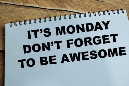 Concept of it's Monday don't forget to be awesome write on book isolated on Wooden Table.