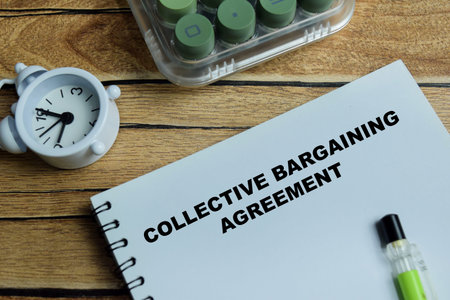 Concept of collective bargaining agreement write on book isolated on Wooden Table.