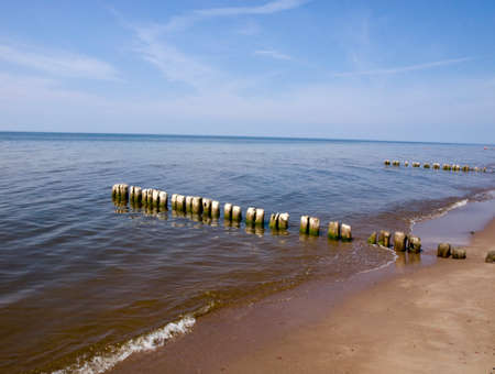 An old wooden breakwater full of holes.の写真素材