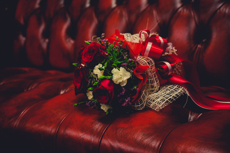 rose bouquet on red sofa and dark filter for feel blue - can use to display or montage productの写真素材