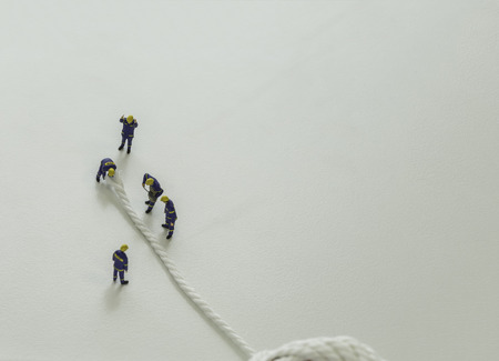 mini team of workers cut the white rope on isolate background and leave space for fill text wording...