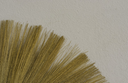 abstract brown broom stay on white cement wall - can use to display or montage on product or concept...