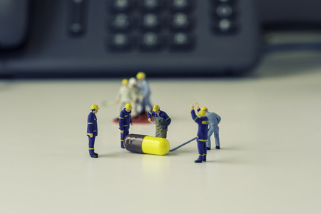 group of mini workers will prove a medicine on white table with vintage filter - can use to display or montage on productsの写真素材