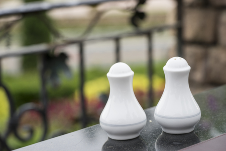 white pepper and salt bottles on the table and garden - can use to display or montage on productsの写真素材