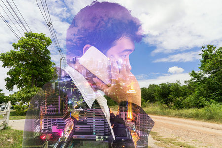 abstract double exposure business man talk a phone with country site and cityscape night - can use to display or montage on productの写真素材