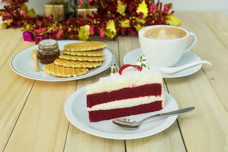 red velvet cake and waffle with huney and coffee on wood table and christmas backdrop - can use to display or montage on productの写真素材