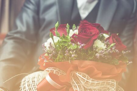 abstract wedding bouquet with red rose in a man and sweet soft filter - can use to display or montage on productの写真素材