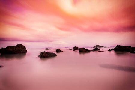 abstract sunset scene of rock in sea with cloudscape - can use to display or montage on productの写真素材