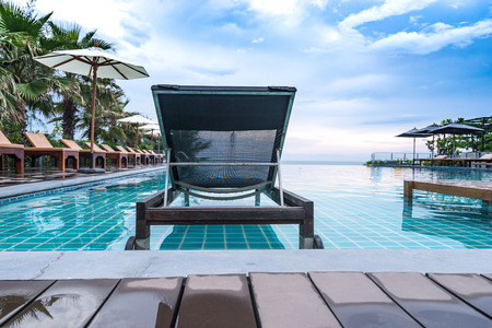 relax wood chair in pool for holiday vacation and clear blue skyの写真素材