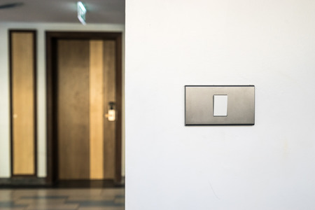 light switch on white wall and door room - can use to display or montage on productの写真素材