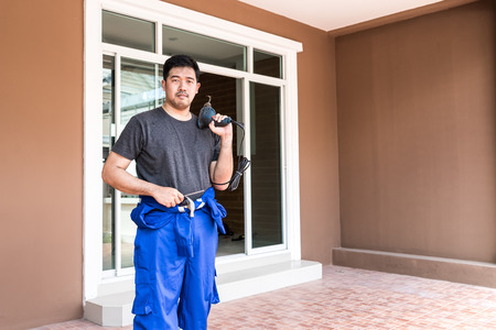 locksmith prepare to repair house in half of blue working jump suit