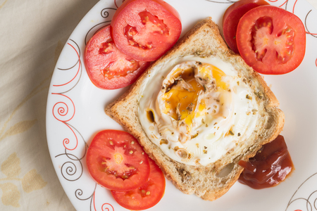Eggs fired and sauce on bread with tomatoesの写真素材