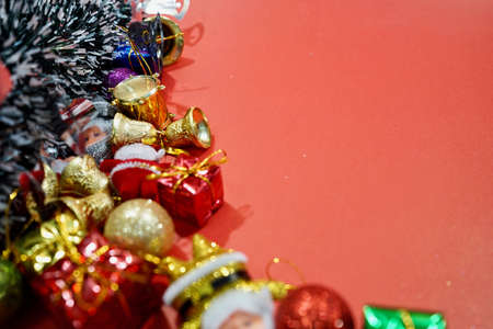 Christmas frame with fir branches, red balls, garland top view on red background. Space for text,...