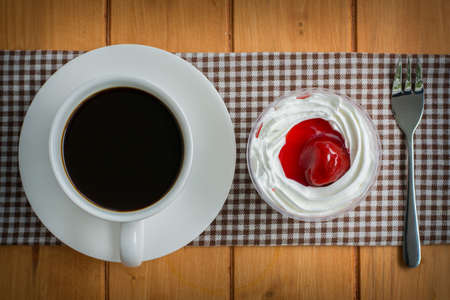 White coffee cup with strawberry cake on wooden tableの写真素材