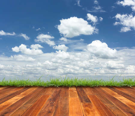 wood floor and green grass on cloudy sky backgroundの写真素材